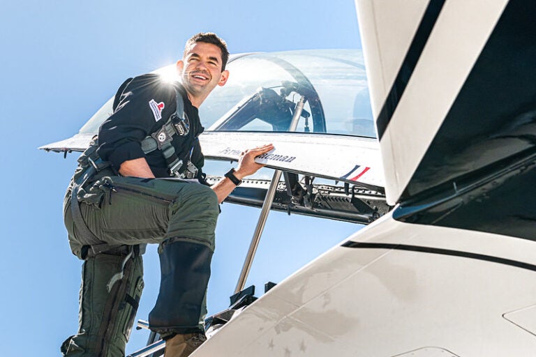 Jared Isaacman poses near a jet cockpit