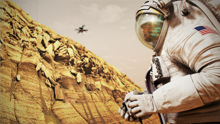 An astronaut stands by a cliff on Mars, looking up at a drone