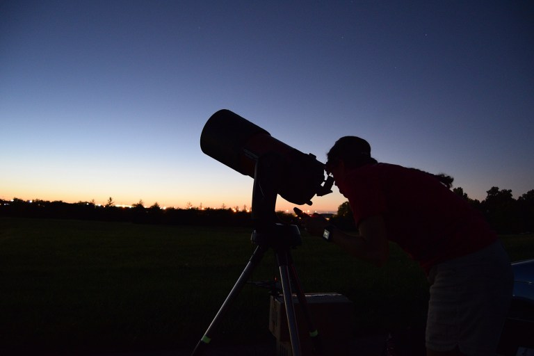 Anyone can get started with observing, thanks to the Astronomical League’s programs. Here, the author peers through her telescope in the twilight.