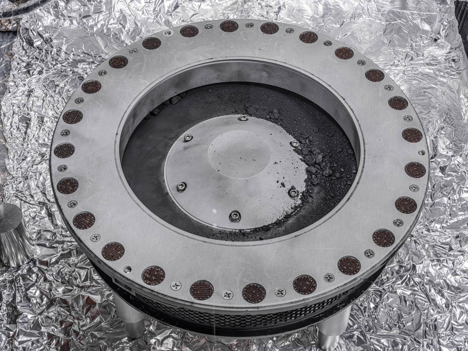 Bennu regolith scattered around the outside of OSIRIS-REx's sample collector