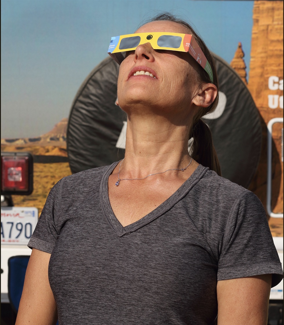 During the partial phases of the eclipse you need proper eye protection, such as the safe eclipse-viewing glasses the author’s wife, Deborah Carter, is wearing, to watch the Moon as it covers the Sun.