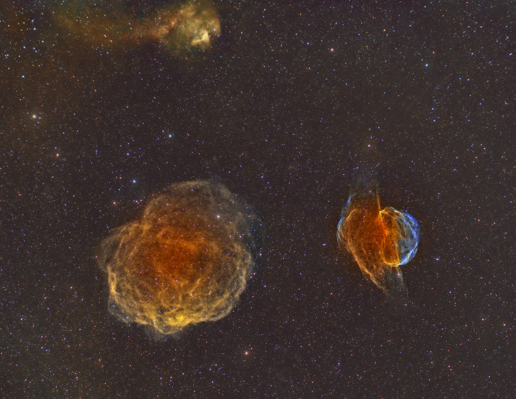 Three nebulae in shades of orange and blue.