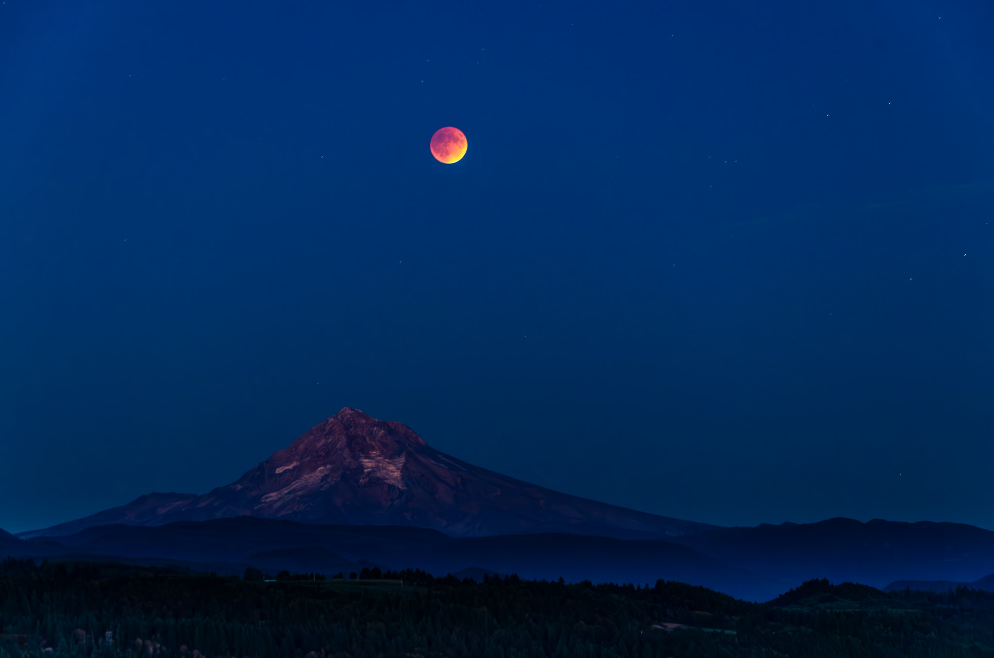 total lunar eclipse above a mountain