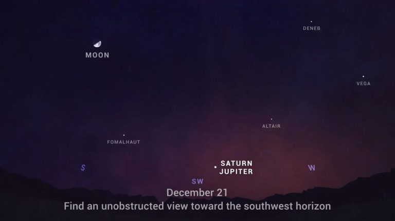 A dark night sky chart transitions from a deep purple at the top to a warm orange glow along a jagged black mountain horizon at the bottom. A crescent moon and several small, white star dots are scattered across the sky, each accompanied by a white text label. In the lower-center of the frame, a single bright white dot sits next to the bold labels "SATURN" and "JUPITER" just above the date text "December 21."