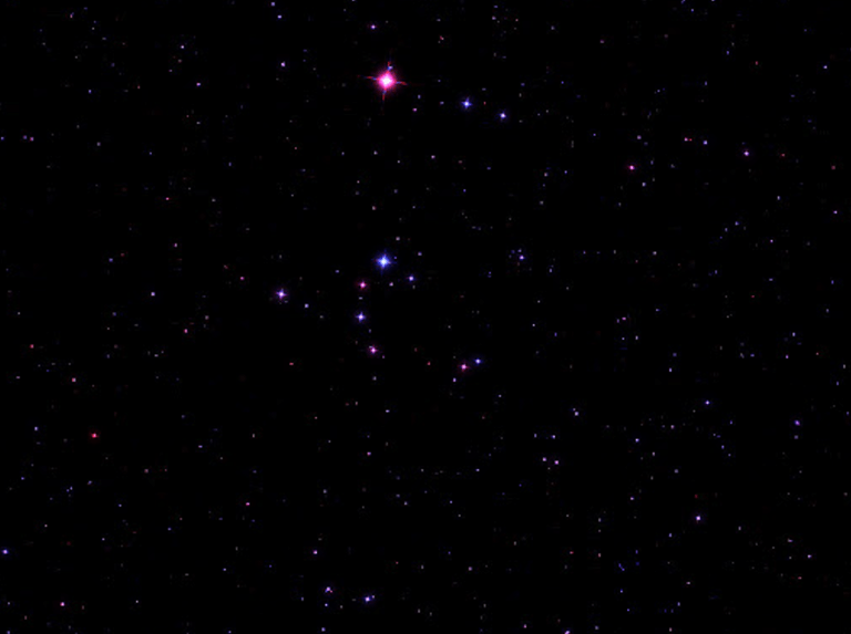 The Broken Engagement Ring asterism, a semicircle of stars of varying brightness and color, set against the dark night sky near the star Merak in Ursa Major.