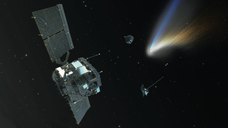 An artist's illustration of the ESA Comet Interceptor mission, showing the large main spacecraft in the foreground with its deployed solar panels, flanked by two smaller sub-probes, all approaching a comet whose bright white nucleus and two-toned tail — blue ion tail and golden dust tail — dominate the upper right of the image against a starry black background.
