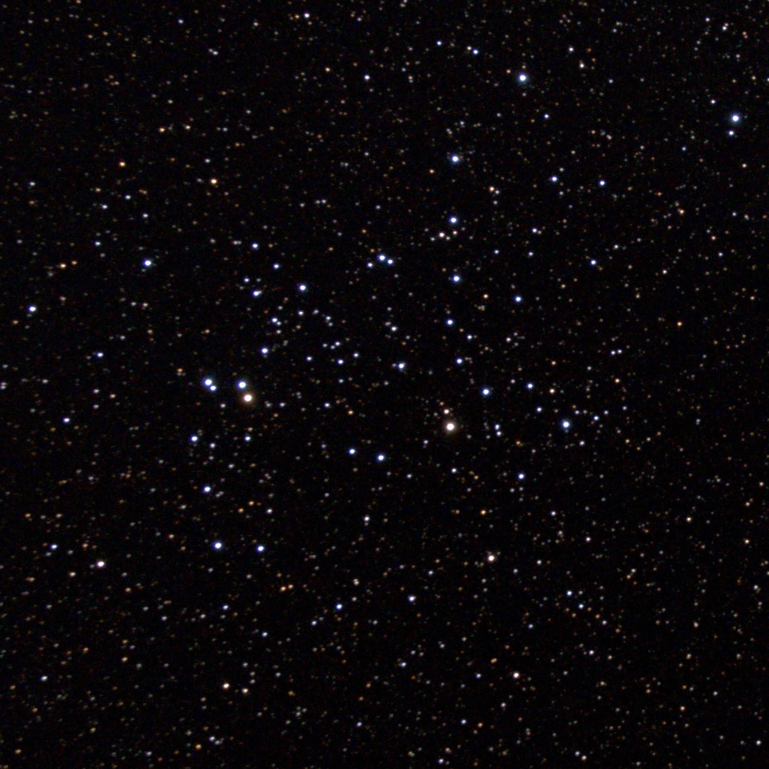 A telescopic photograph of NGC 6709, an open star cluster set against a dense, star-filled black sky. The cluster's members are scattered loosely across the frame, with a mix of bright blue-white stars and fainter orange and yellow background stars, and two noticeably brighter stars near the left-center of the cluster.
