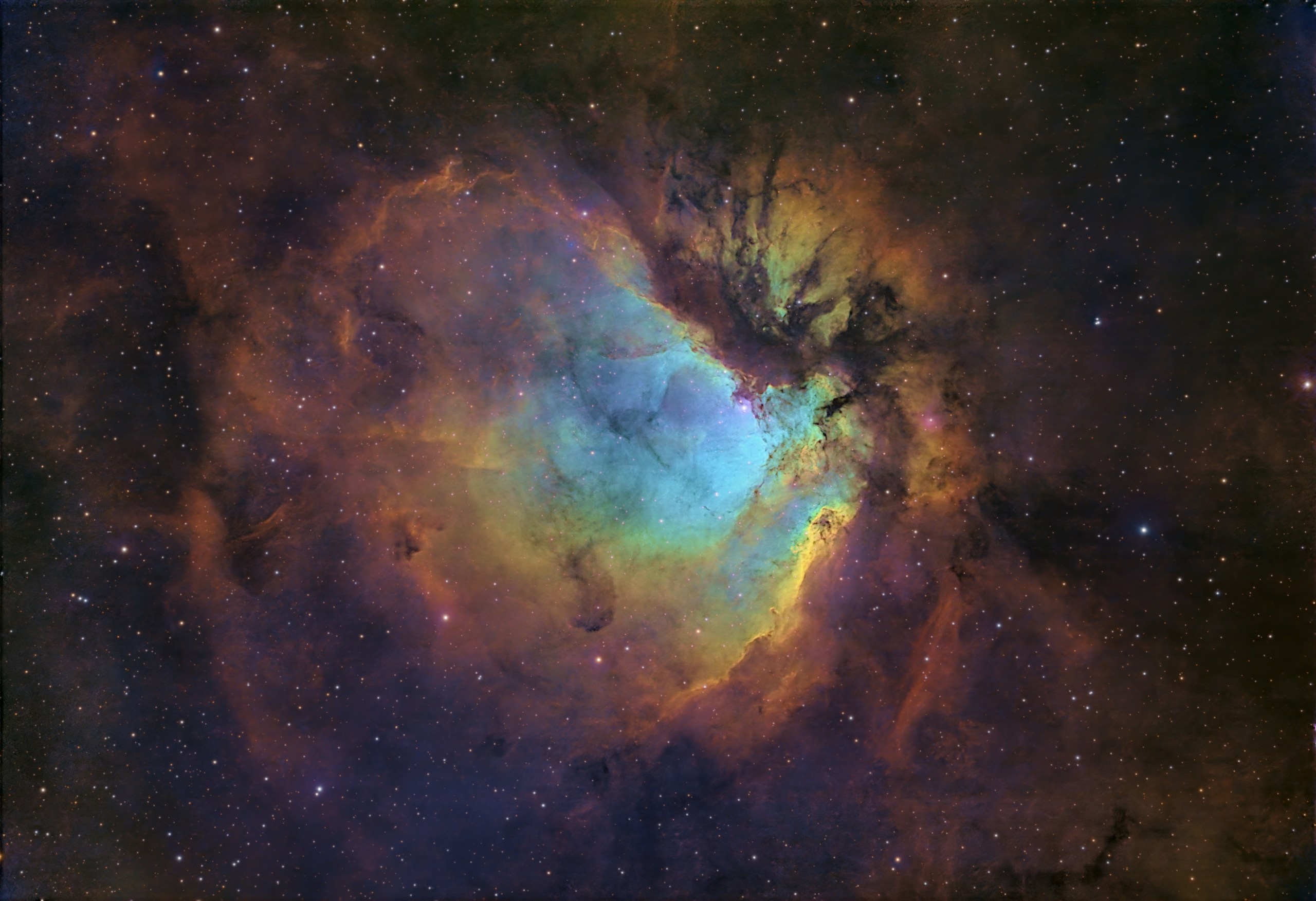 A large, glowing cloud of gas fills the frame against a dense starfield. Its center glows teal and blue, ringed and streaked by billowing gold, orange, and rust-brown clouds, with dark lanes of dust winding through the right side. The colors are vivid and painterly.