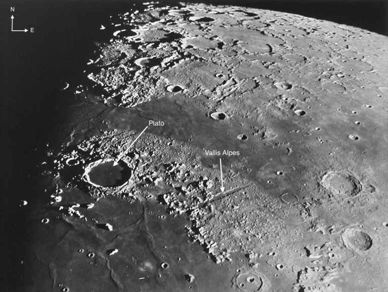 A black-and-white image of the Moon, showing northeastern Mare Imbrium with Plato and Vallis Alpes labeled. North is up and east is left.