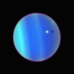 Earth-based telescopes easily show Uranus’ distinctive blue-green color. This 2006 Hubble Space Telescope image also reveals banding in the atmosphere as well as a rare transit by the planet’s moon Ariel (the white dot) and its shadow (to the right). Credit: NASA/ESA/L. Sromovsky (University of Wisconsin–Madison).