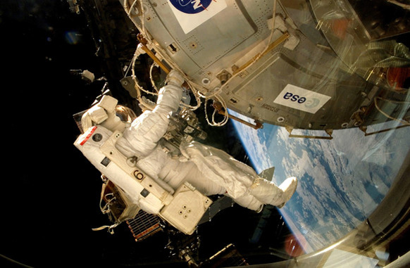 An astronaut fixes the EXPOSE-E platform onto the International Space Station.