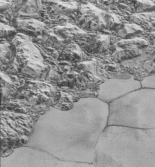 Great blocks of Pluto’s water-ice crust appear jammed together in the informally named al-Idrisi mountains. 