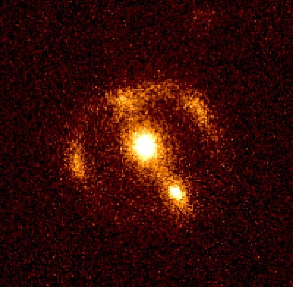 An irregular ring of radiation can be seen around the distant galaxy in the center of this 2.2-micron CCD photograph.