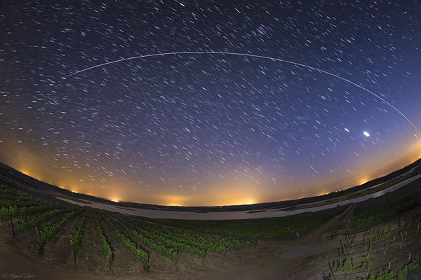 The International Space Station streaks through the starry sky above vineyards in Portugal.