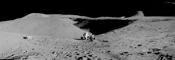 This view from the slopes of Mount Hadley Delta, near St. George Crater, takes in the Hadley Rille. On the left is a boulder that Scott and Irwin sampled.