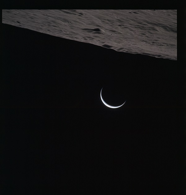 A crescent Earth rises over the wall of Humboldt Crater in this shot taken by Al Worden.