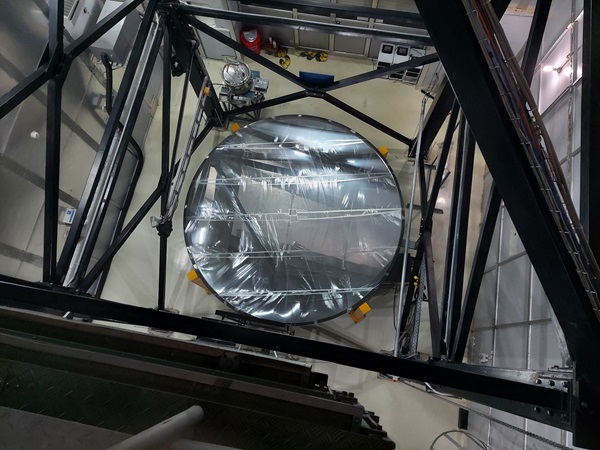 An overhead view of a telescope mirror surrounded by scaffolding.