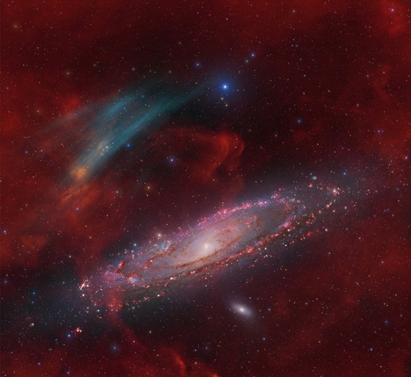 The spiral galaxy Andromeda lies in the bottom half of the frame. Above and to its left is a teal banded arc roughly half as wide as the galaxy.