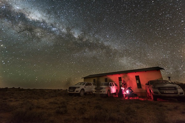 Observers with a telescope under the milky way
