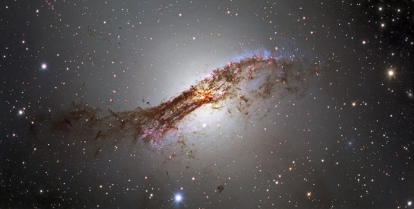 Dark tendrils of dust curl around the outskirts of the galaxy Centaurus A.