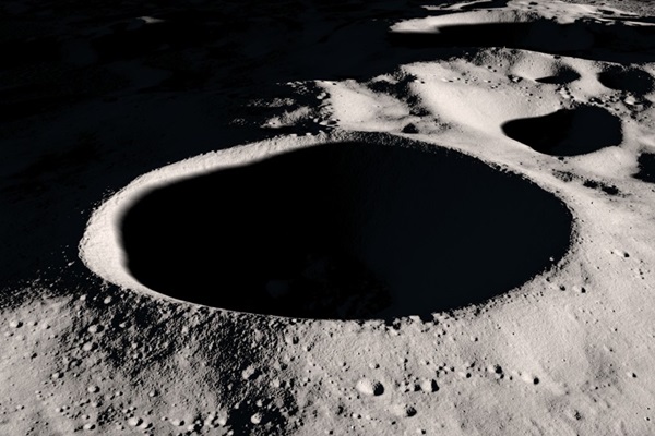 A 21-kilometer-wide crater on the Moon, with only its rim lit, a bowl of darkness inside