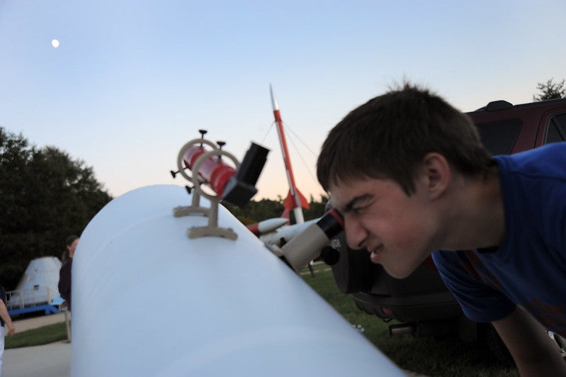 Child looking through telescope International Observe the Moon Night