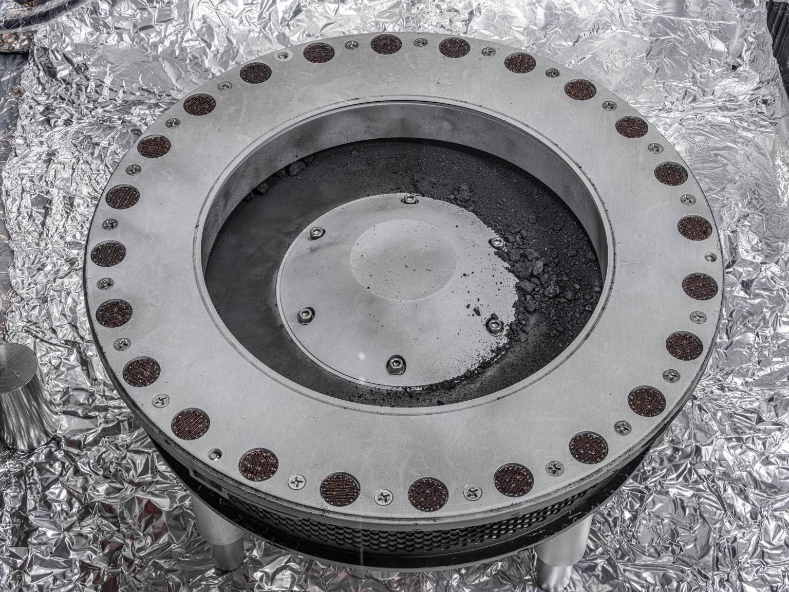 Bennu regolith scattered around the outside of OSIRIS-REx's sample collector