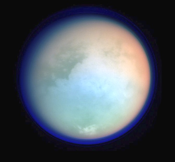 Titan’s dense atmosphere (dark blue) extends hundreds of miles above the world’s surface, as seen in this false-color mosiac captured by the Cassini spacecraft.