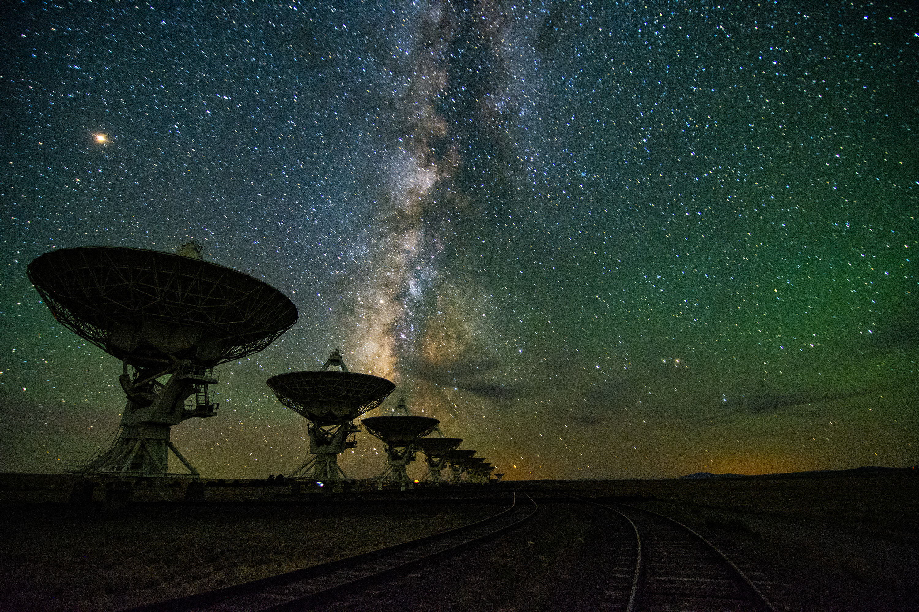 Dishes of the Karl G. Jansky Very Large Array in New Mexico line up beneath the starry sky. Radio waves are just one of the numerous signals from space that comprise the soundtrack of the cosmos.