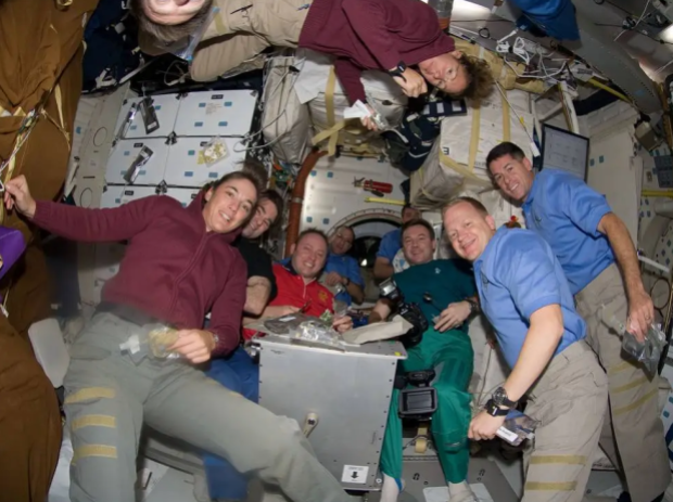 An image of the Expedition 18 and STS-126 astronauts on the space shuttle's middeck sharing a Thanksgiving meal.