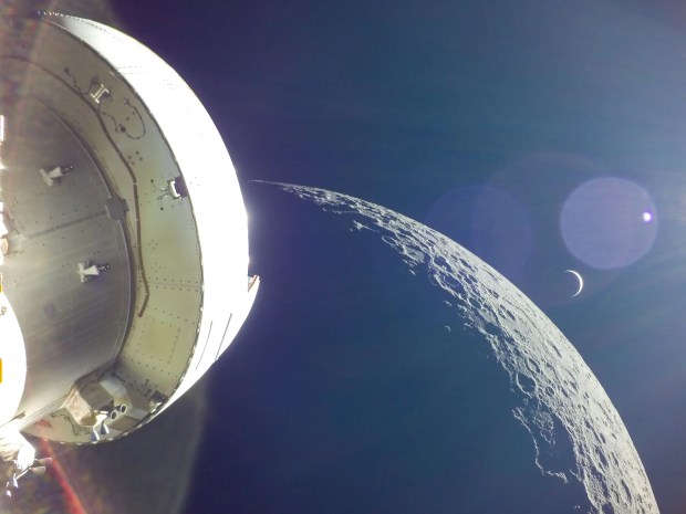 During the Artemis test mission in 2022, Orion passes close to the Moon’s surface, with Earth a small crescent in the background. Credit: NASA