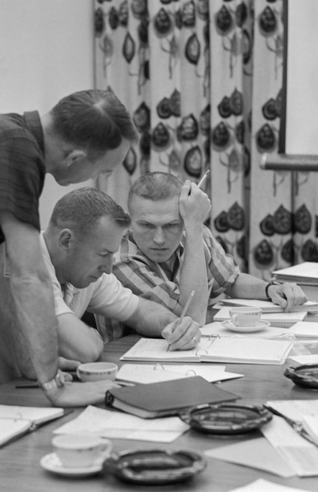 James Lovell Jr. (center) and Frank Borman (right) review mission requirements for their Gemini-7 flight. Photo credit: NASA