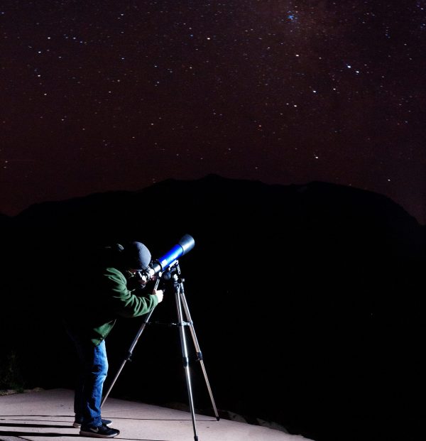 A person observing the night sky with a telescope.