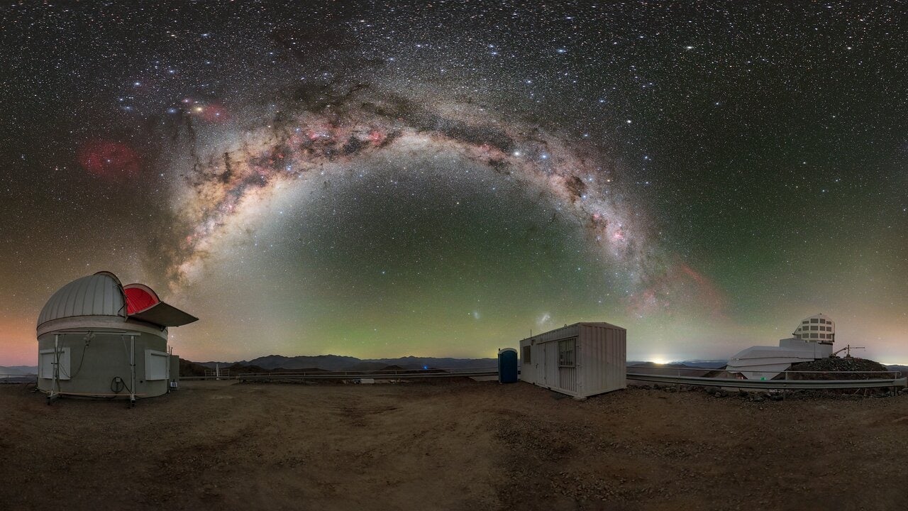 The Milky Way, shown above the Rubin Auxiliary Telescope (left) and the Vera C. Rubin Observatory (far right),. Credit: Rubin Observatory/NOIRLab/NSF/AURA/P. Horálek (Institute of Physics in Opava)