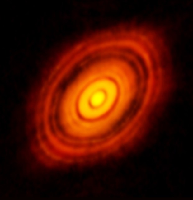 Radio observations of the young star HL Tauri reveal a massive protoplanetary disk of dust and gas surrounding the star (at the center). Nascent planets can affect the material orbiting in the disk, causing instabilities and carving out gaps. Researchers are now using AI to help identify subtle signs of planet formation within such disks.
