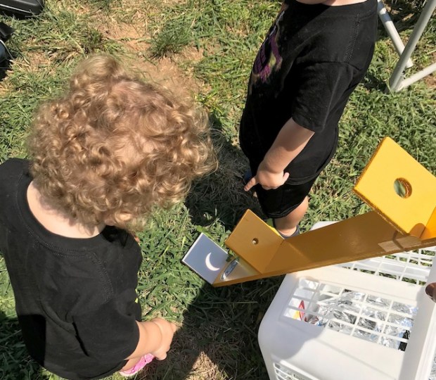 The author’s grandchildren view the partial phases of the 2017 eclipse with a homebuilt Advanced Safe Solar Viewer.