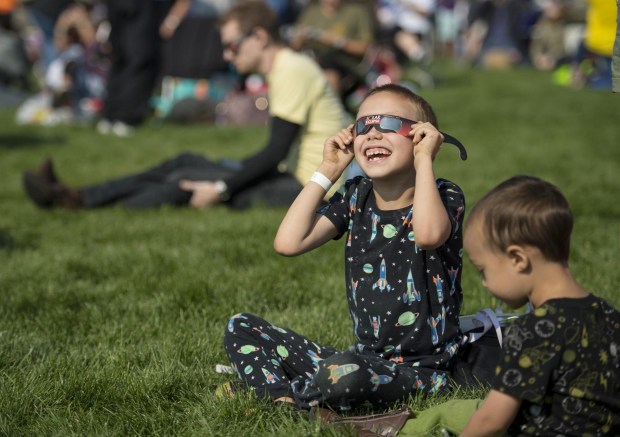 A boy watches the total solar eclipse through protective glasses in Madras, Oregon on Monday, Aug. 21, 2017. Credit: NASA/Aubrey Gemignani
