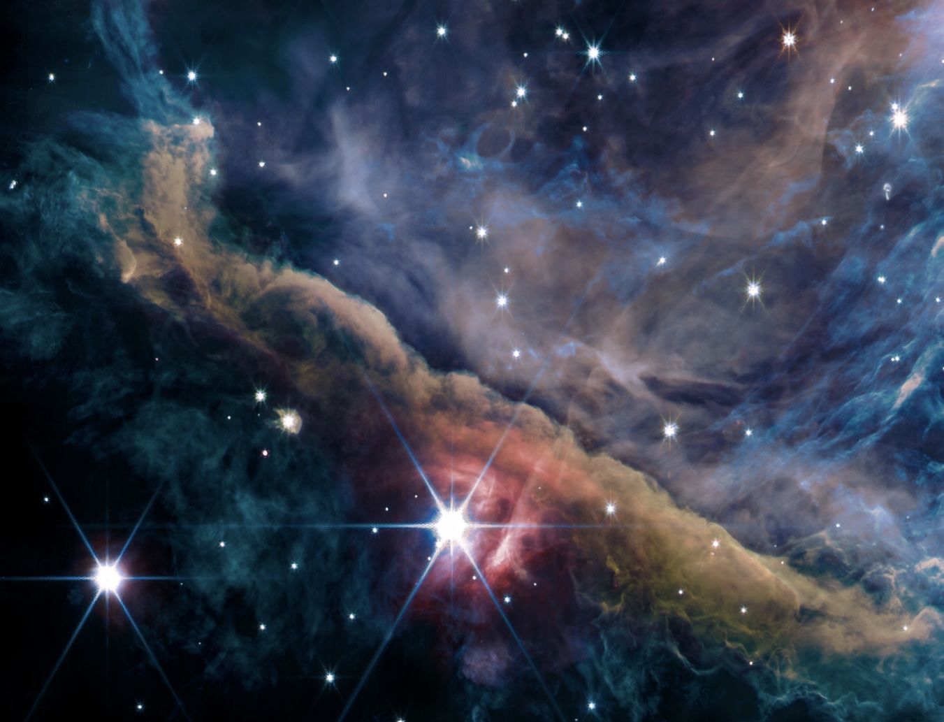 The Orion nebula as seen by the JWST, appears like a pillowy, colorful, massive cloud of gas and dust.