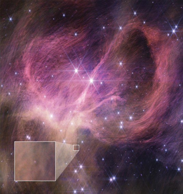 An image from the James Webb Space Telescope showing wispy pink-purple filaments and a scattering of stars.