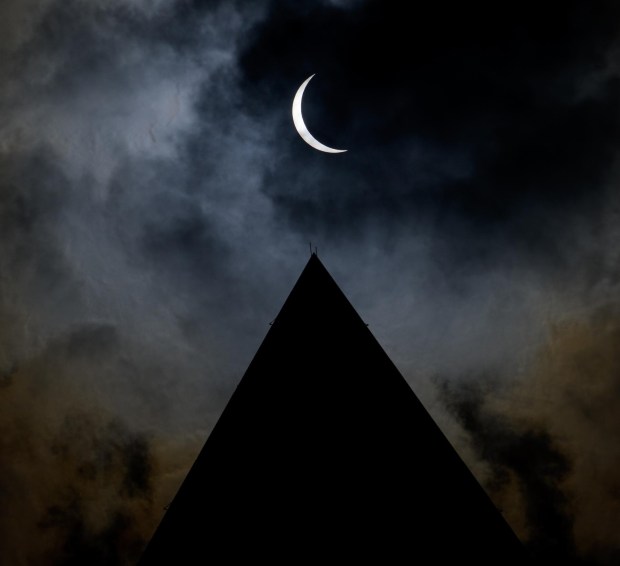 The Moon is seen passing in front of the Sun, with the top of the Washington Monument in silhouette, during a partial solar eclipse in Washington, on Monday, April 8, 2024. Photo Credit: (NASA/Bill Ingalls)