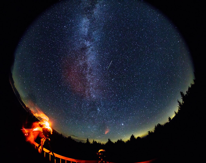a meteor streaks overhead near the Milky Way