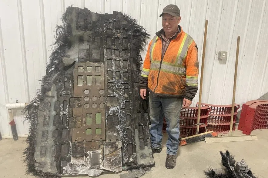 Barry Sawchuk stands next to some of the space debris he found on his farm. Credit: Twitter/Gillian Massie/980 CJME.