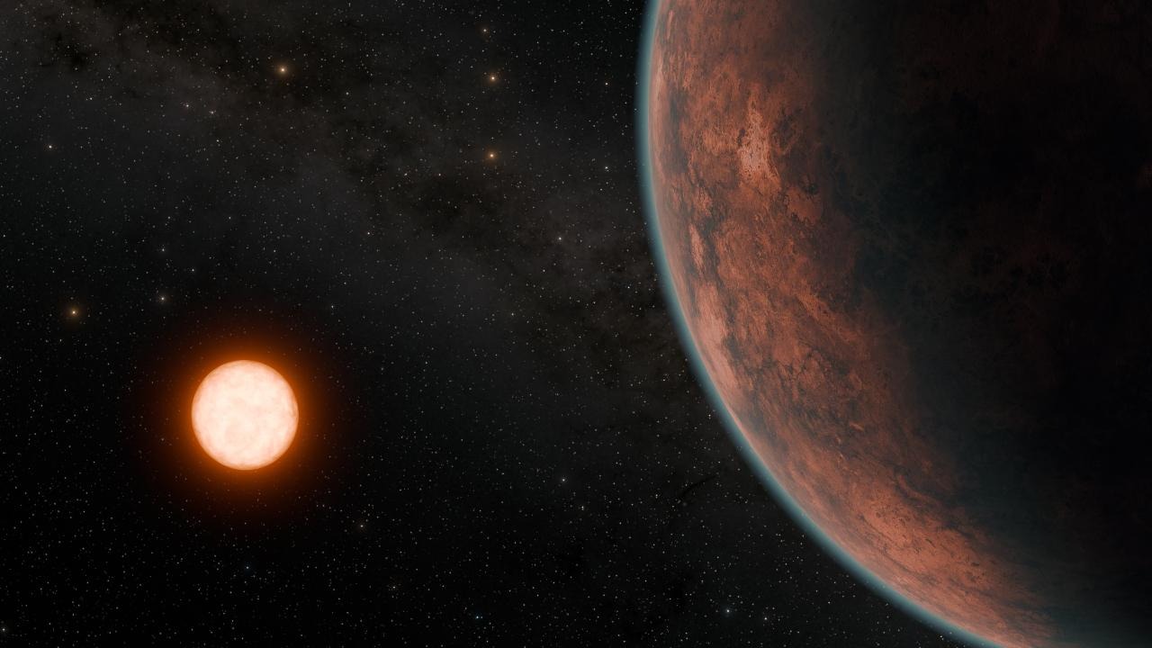 An artistic conception of Gliese 12 b, shows the exoplanet in the foreground at right while the red dwarf star glows brightly in the distance at left.