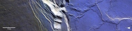 This image shows a slice of the frost-coated caldera atop Olympus Mons. Note how the frost is absent on the slopes that are well lit by sunlight. Credit: ESA/TGO/CaSSIS, CC-BY-SA 3.0 IGO.